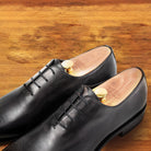 A Pair of Graphite leather dress shoe on a wooden surface