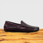 Merlot loafer shoe with woven pattern on a wooden surface
