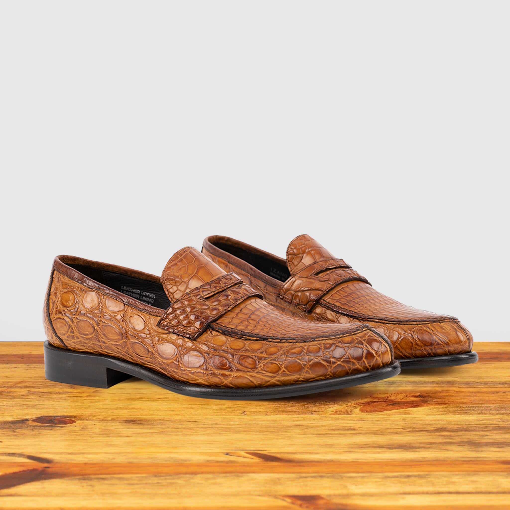A Pair of Brick leather loafer on a wooden surface with a light gray background