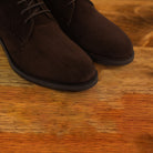 Pair of brown suede boots on a wooden surface