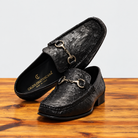 Pair of Black Ostrich Loafer on top of a wooden table