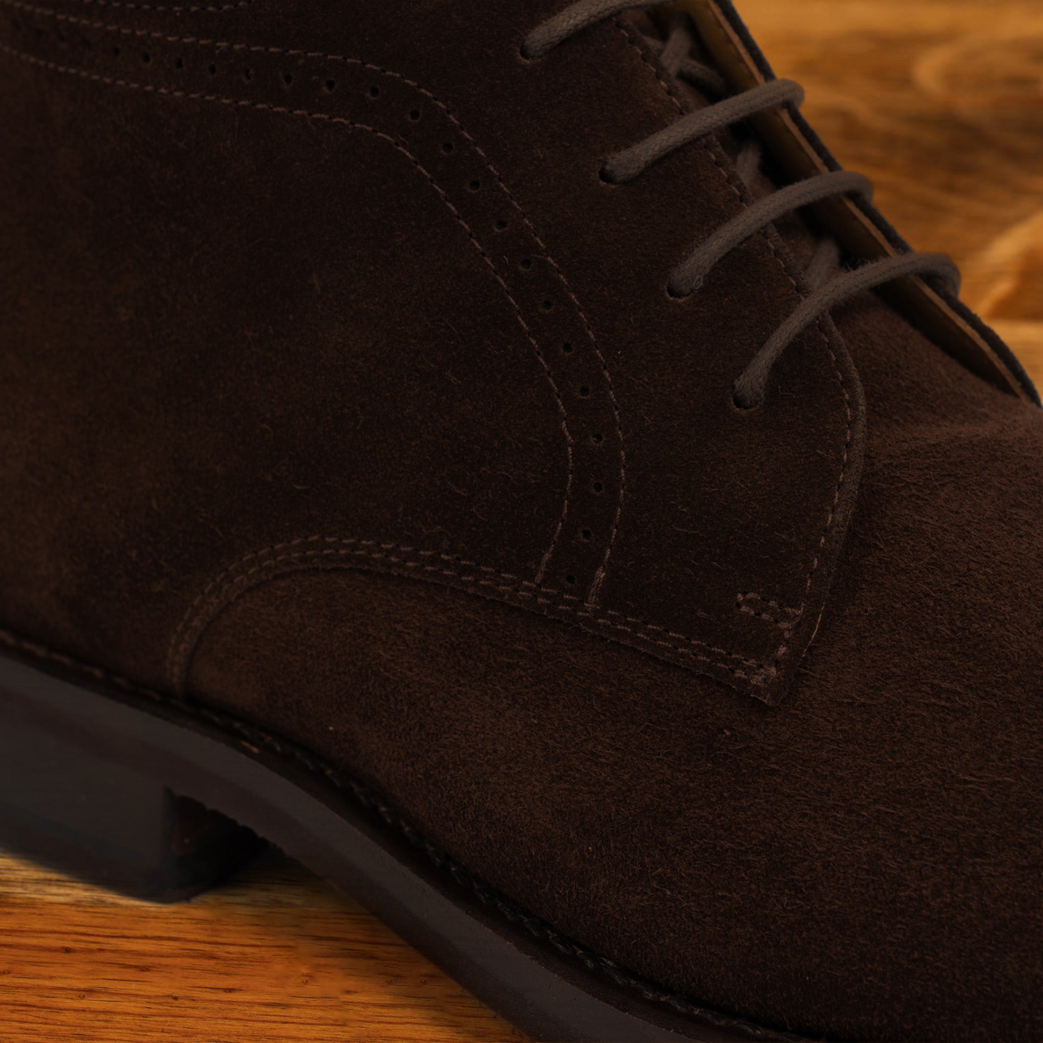 Brown suede boots on a wooden surface