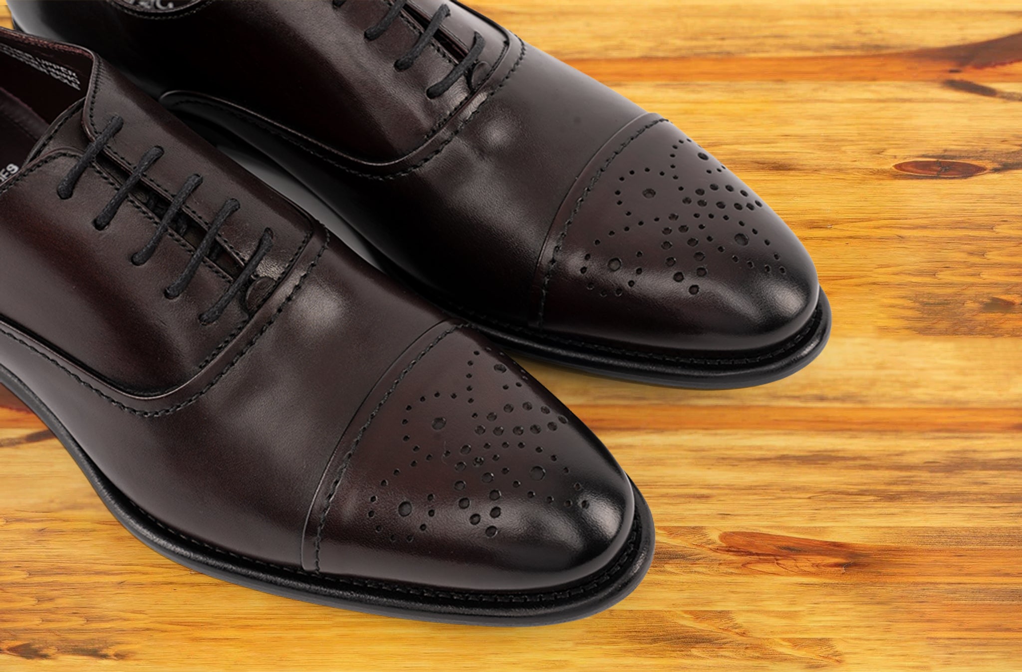 Pair of Burgundy leather dress shoe on a wooden surface