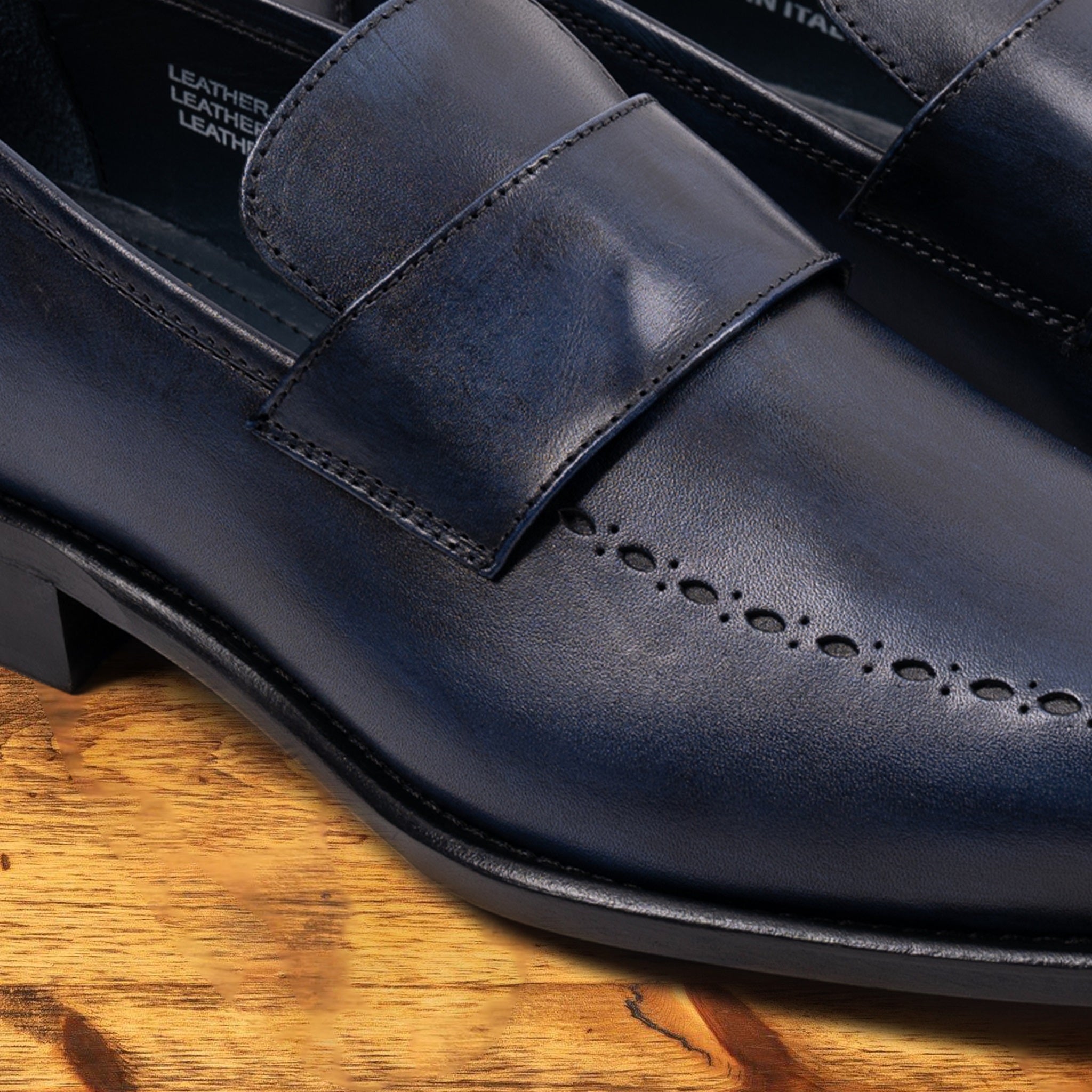 Blue leather loafer on a wooden surface