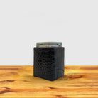Black textured wallet with money on a wooden surface