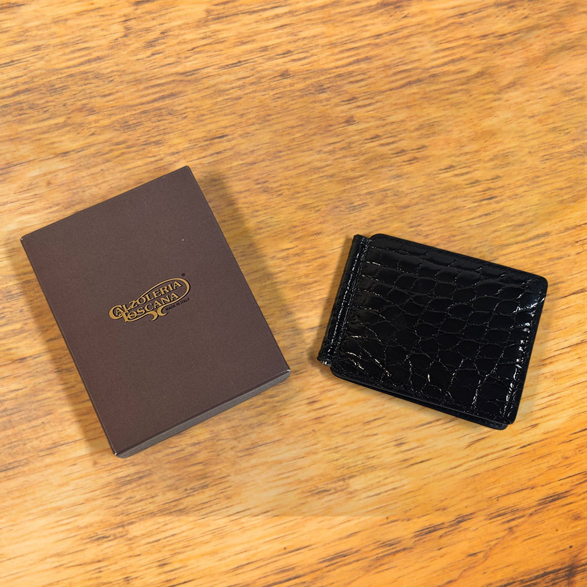 Black textured wallet and a box on a wooden surface