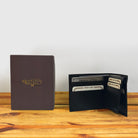 Black wallet  with credit cards and a box on a wooden surface and light gray background