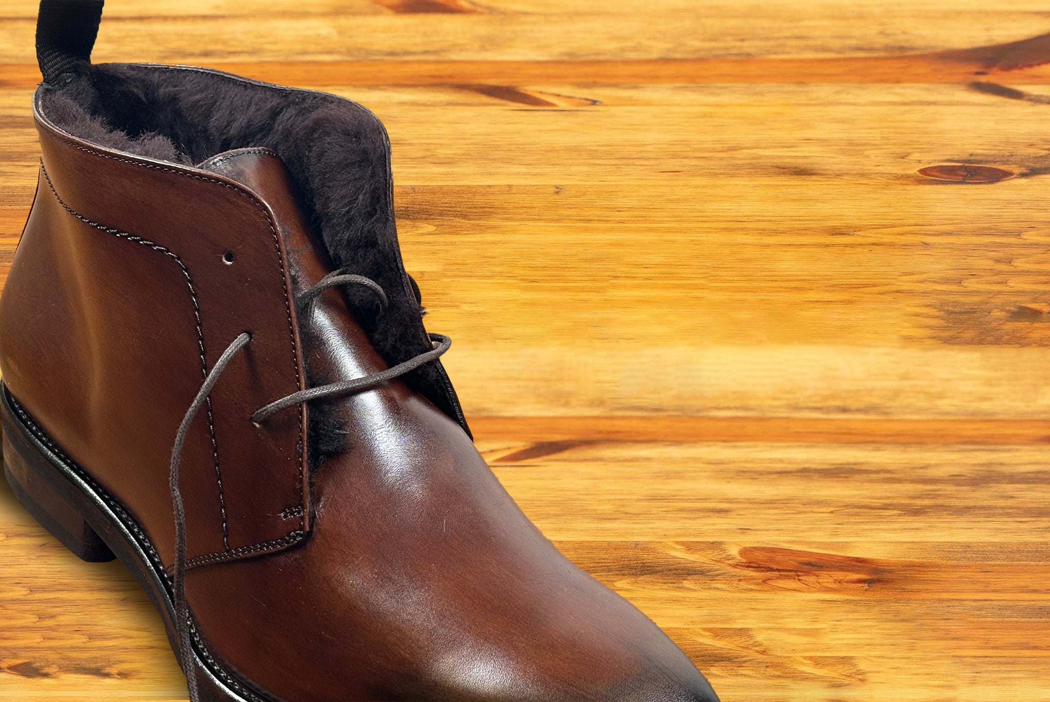 Brown leather boots on a wooden surface