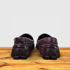 A Pair of Merlot loafer shoe with woven pattern on a wooden surface