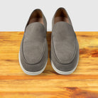 Pair of Gray loafer shoe on a wooden surface with a light gray background
