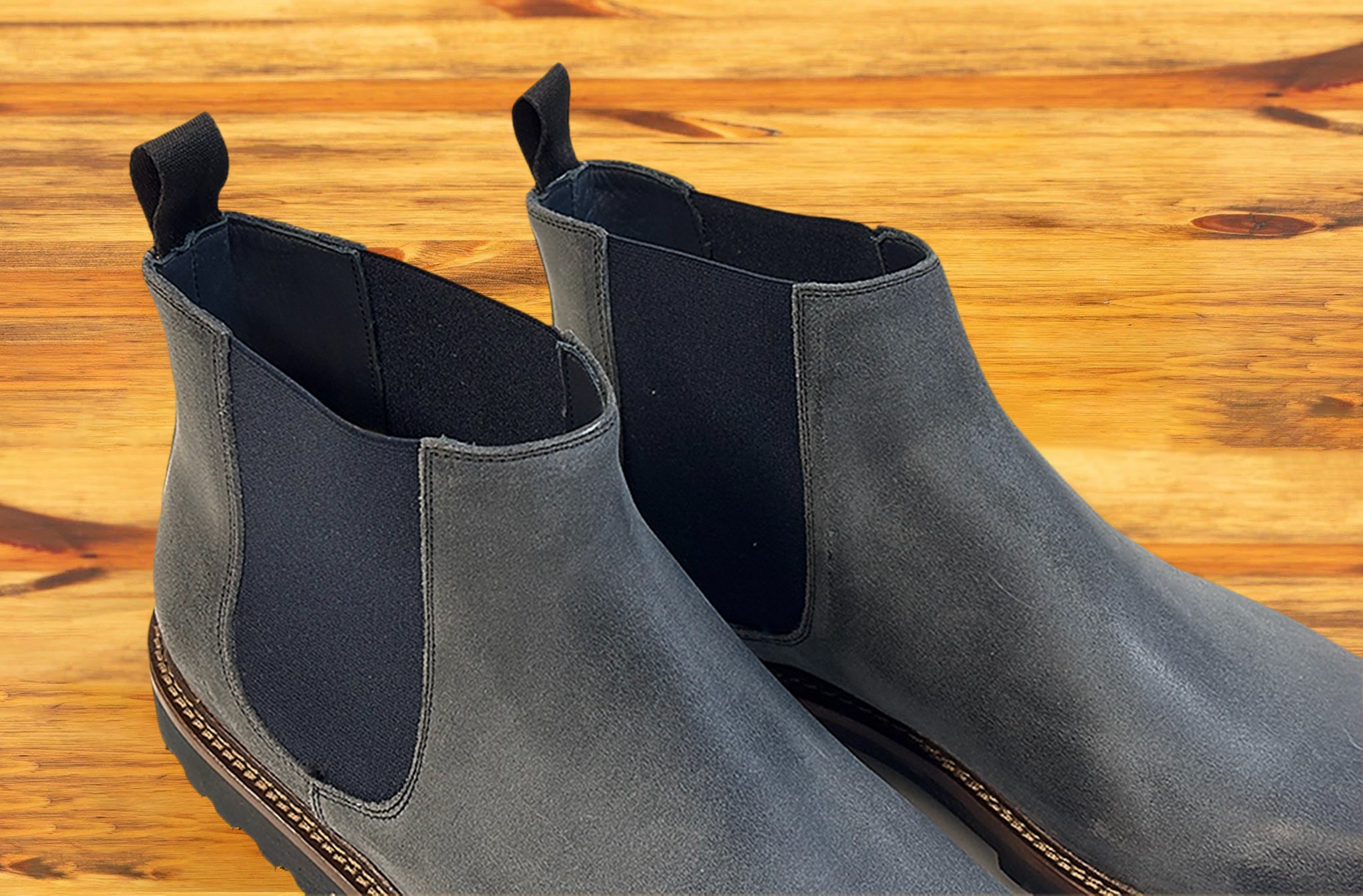 Pair of Stone leather Chelsea boots on a wooden surface