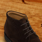 Brown suede boots on a wooden surface 