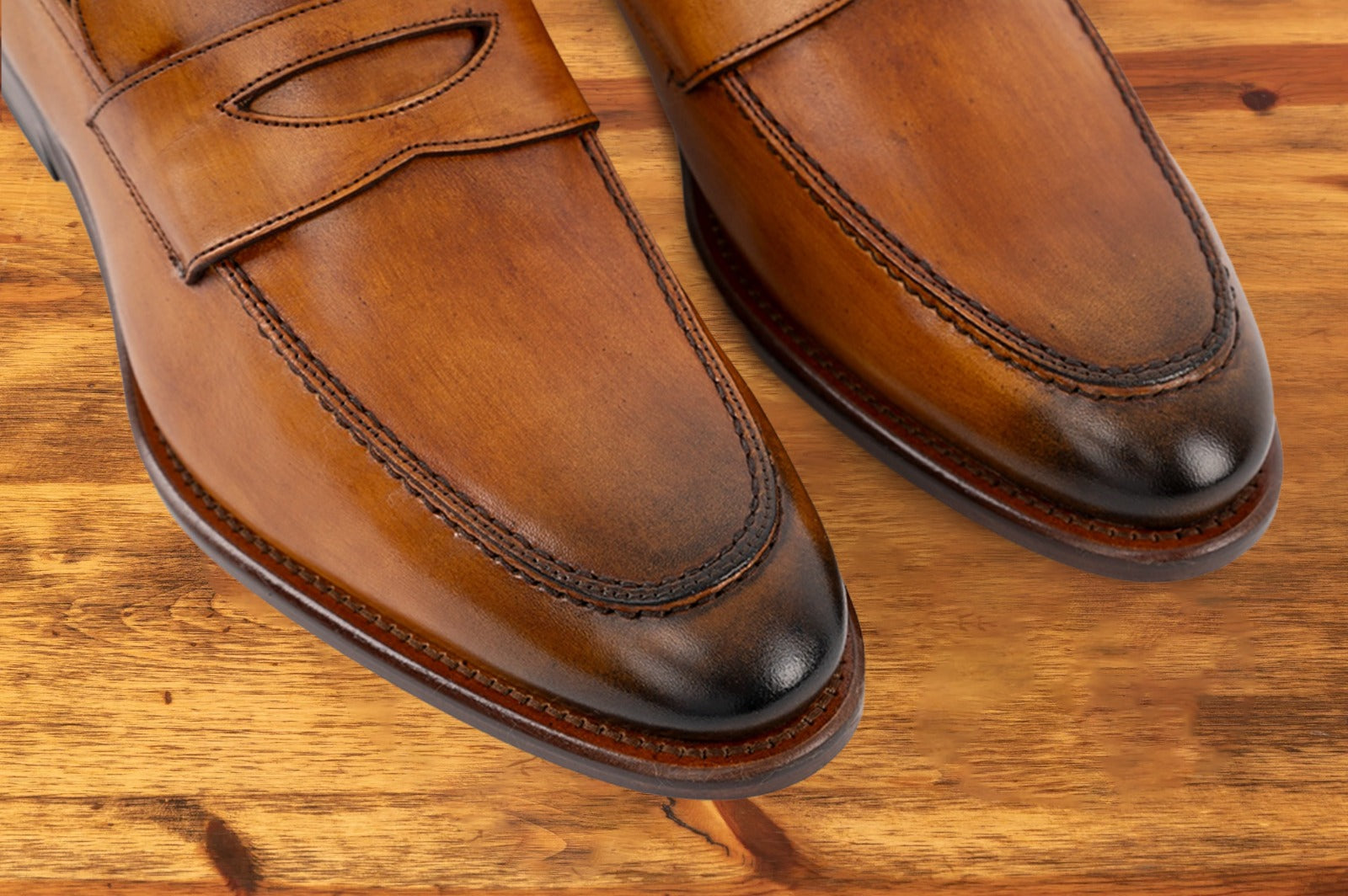 A Pair of Brown leather loafer on a wooden surface