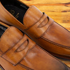 A Pair of Brown leather loafer on a wooden surface