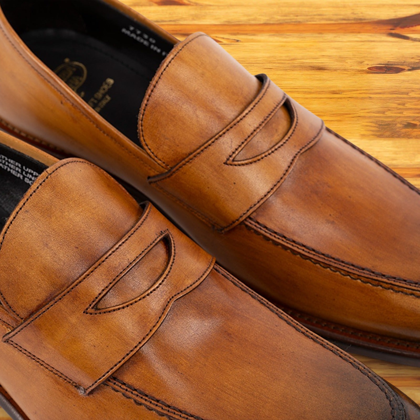 A Pair of Brown leather loafer on a wooden surface