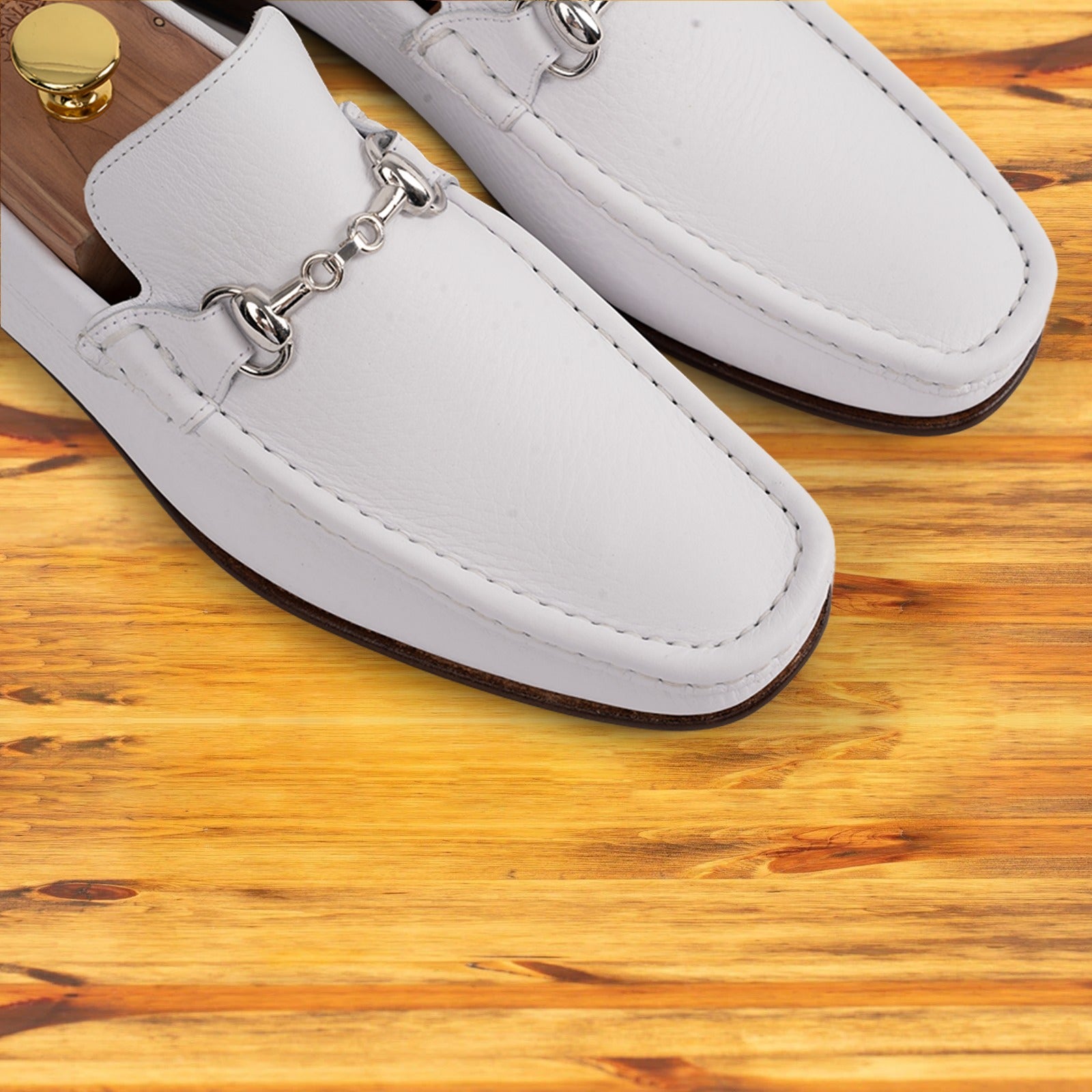 Pair of White loafer shoe on a wooden surface