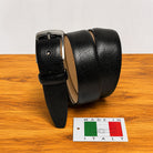 Black leather belt on a wooden surface with a 'Made in Italy' sign.