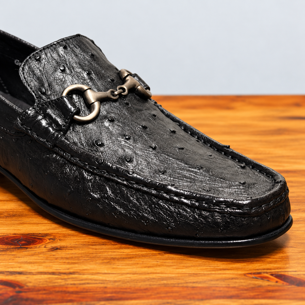 Black Ostrich Loafer on top of a wooden table