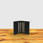 Dark brown textured wallet with credit cards on a wooden surface