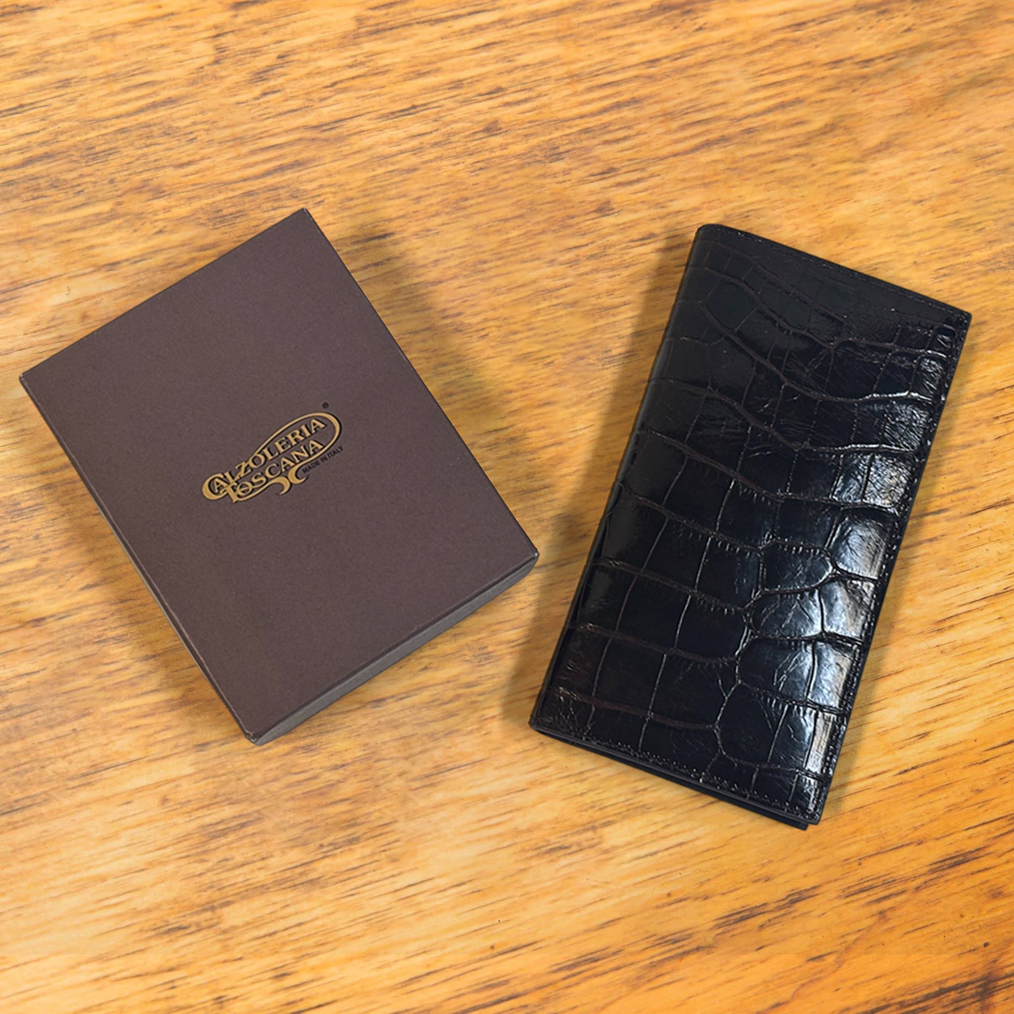 Dark Brown crocodile-patterned wallet and brown box on a wooden surface