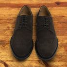 Charcoal suede dress shoe on a wooden surface