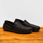 Pair of Dark Brown loafer shoe with woven pattern on a wooden surface