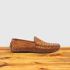 Brick loafer shoe with woven pattern on a wooden surface