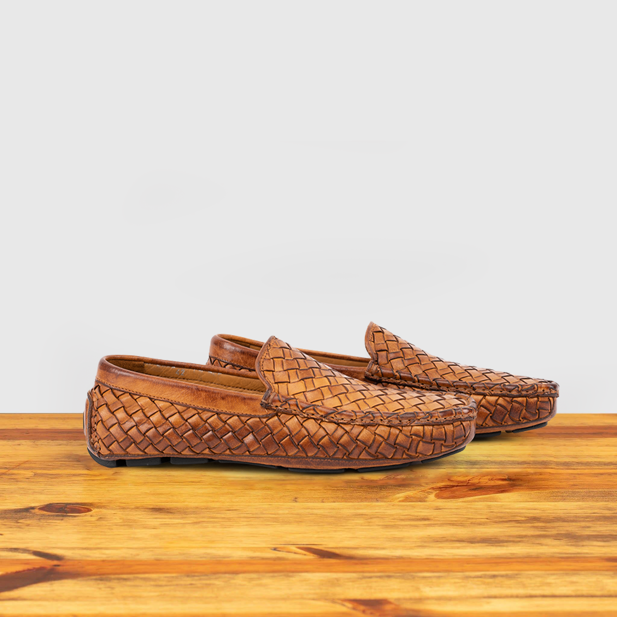 Pair of Brick loafer shoe with woven pattern on a wooden surface