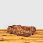 Pair of Brick loafer shoe with woven pattern on a wooden surface