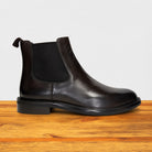 Tobacco leather Chelsea boot on a wooden surface with a light gray background