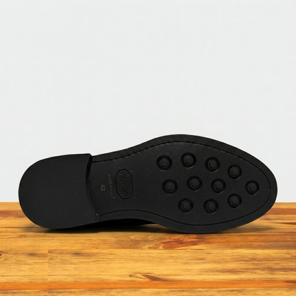Tobacco colored Boot out sole with tread pattern on a wooden surface