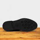 Tobacco colored Boot out sole with tread pattern on a wooden surface