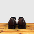 A pair of Brown leather dress shoe on a wooden surface with a light gray background