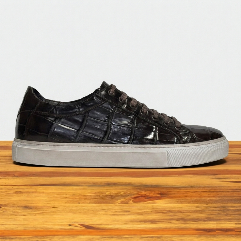 Dark Brown crocodile-patterned sneaker on a wooden surface with a light gray background