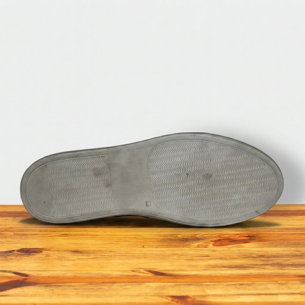Dark Brown shoe sole on a wooden surface with a white background