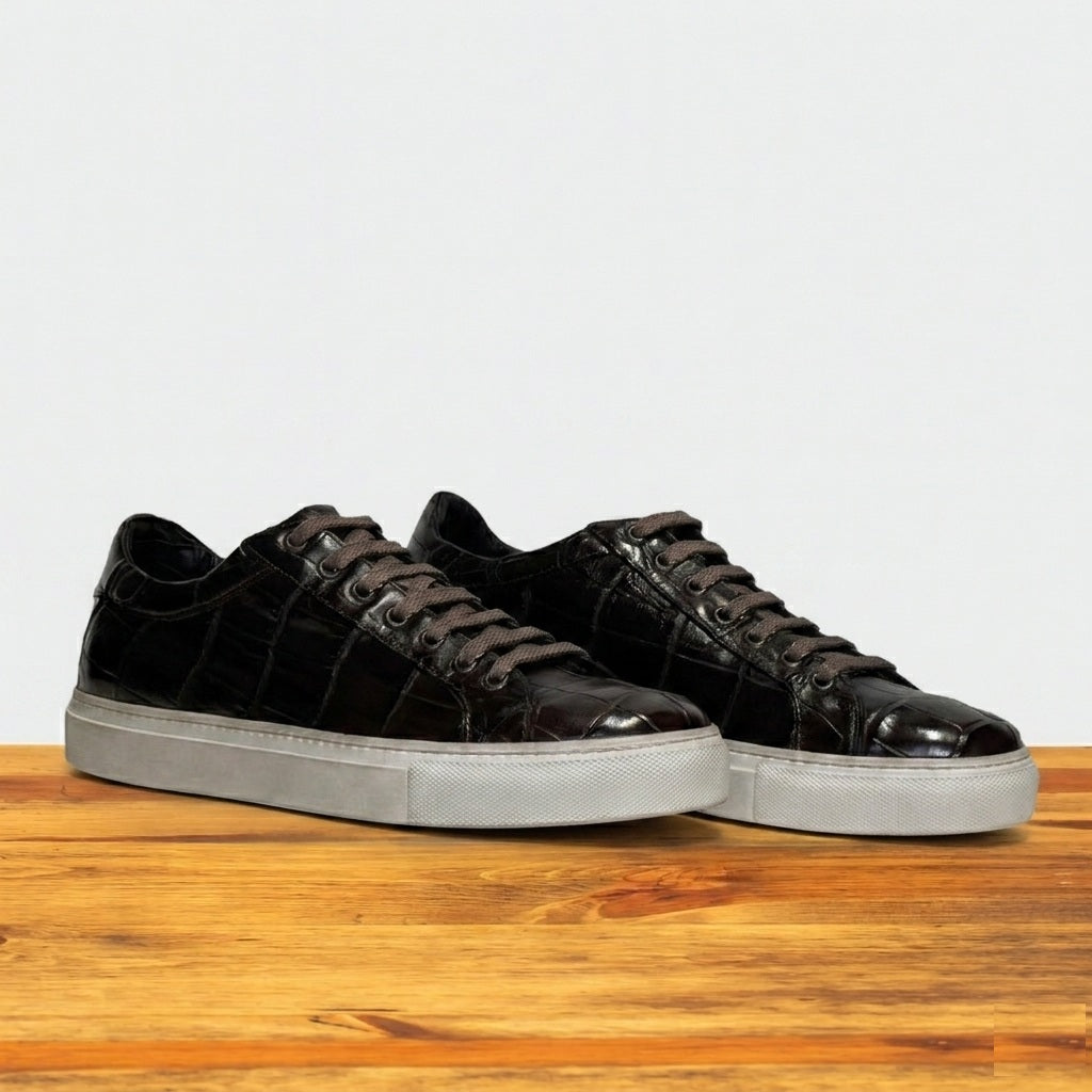 Pair of Dark Brown sneakers with white soles on a wooden surface