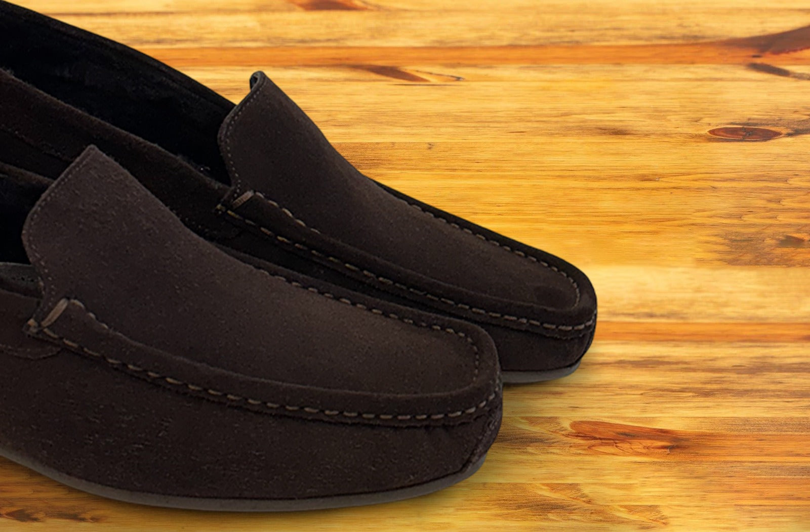 Pair of brown loafers on a wooden surface