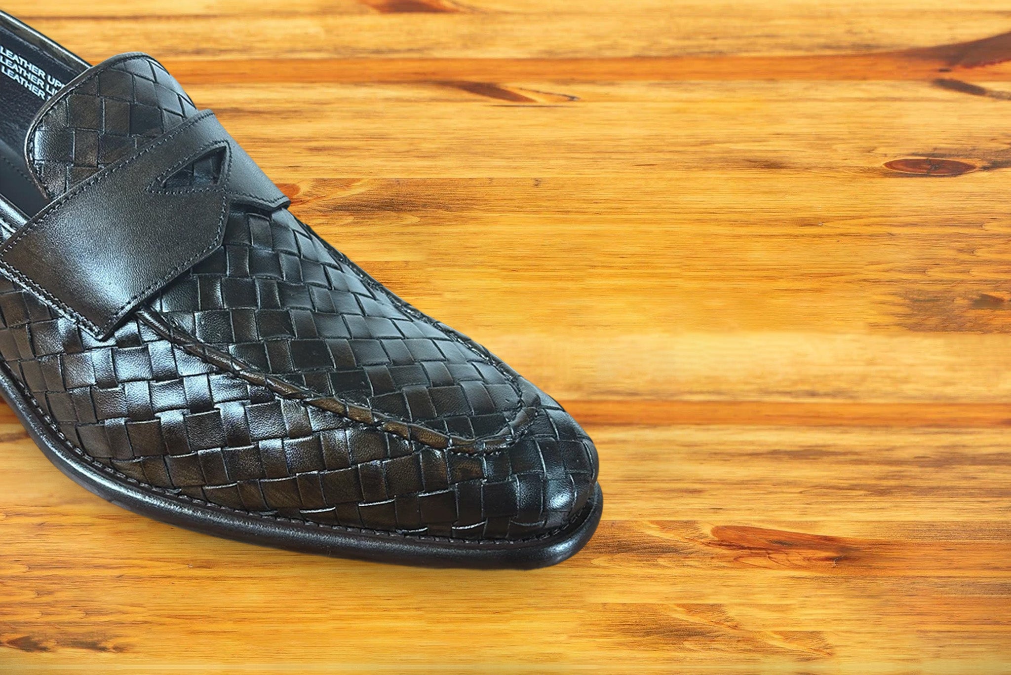 Brown woven loafer shoe on a wooden surface