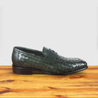 Green woven loafer shoe on a wooden surface with a light gray background