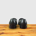 A pair of Green woven loafer shoe on a wooden surface with a light gray background