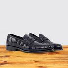 A Pair of Blue leather loafer on a wooden surface with a light gray background
