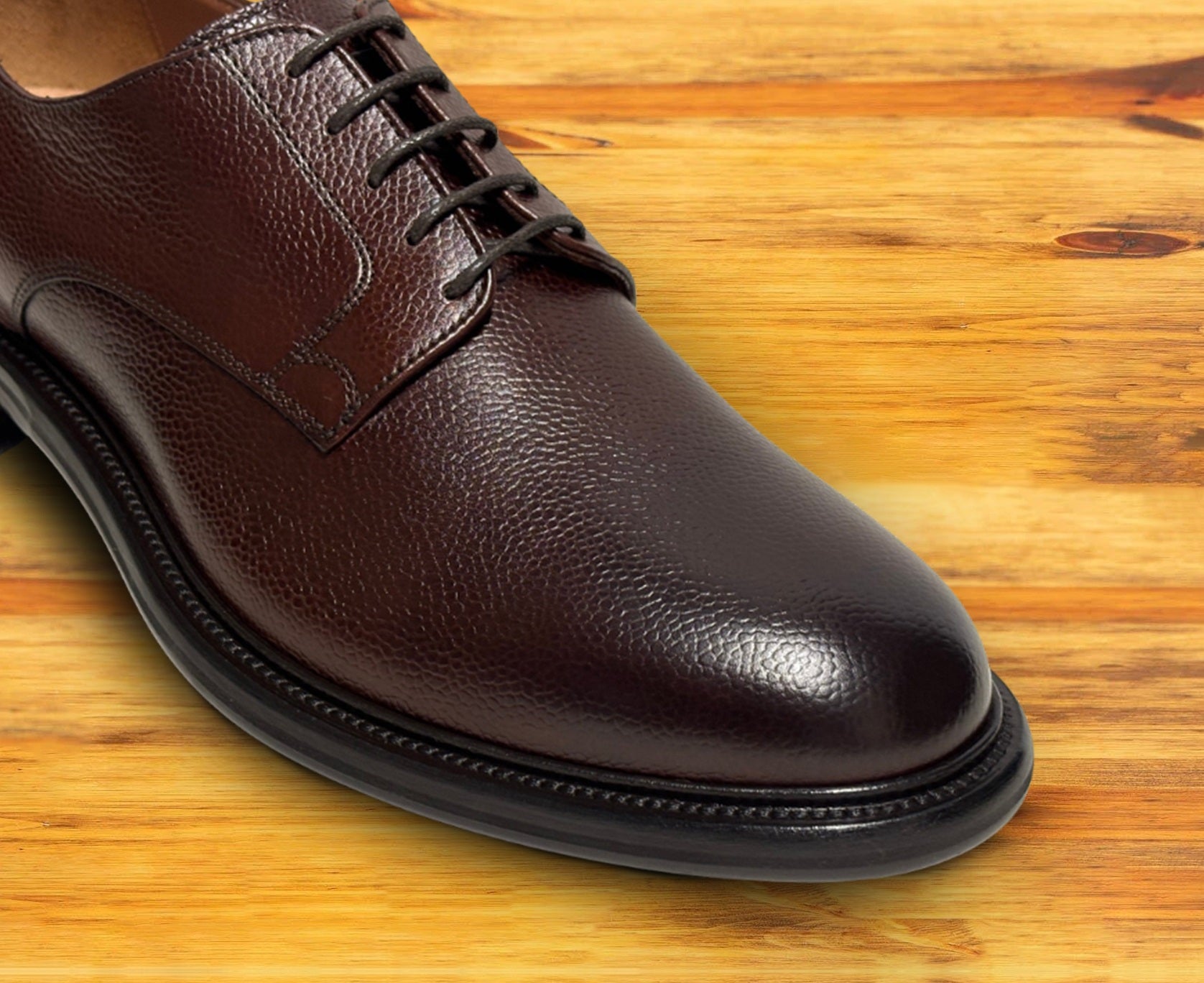 Brown leather dress shoe on a wooden surface