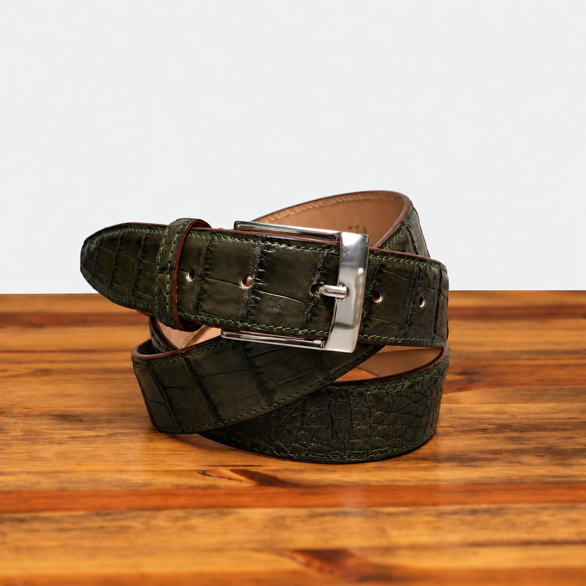 Olive Green Hornback Belt on top of a wooden table