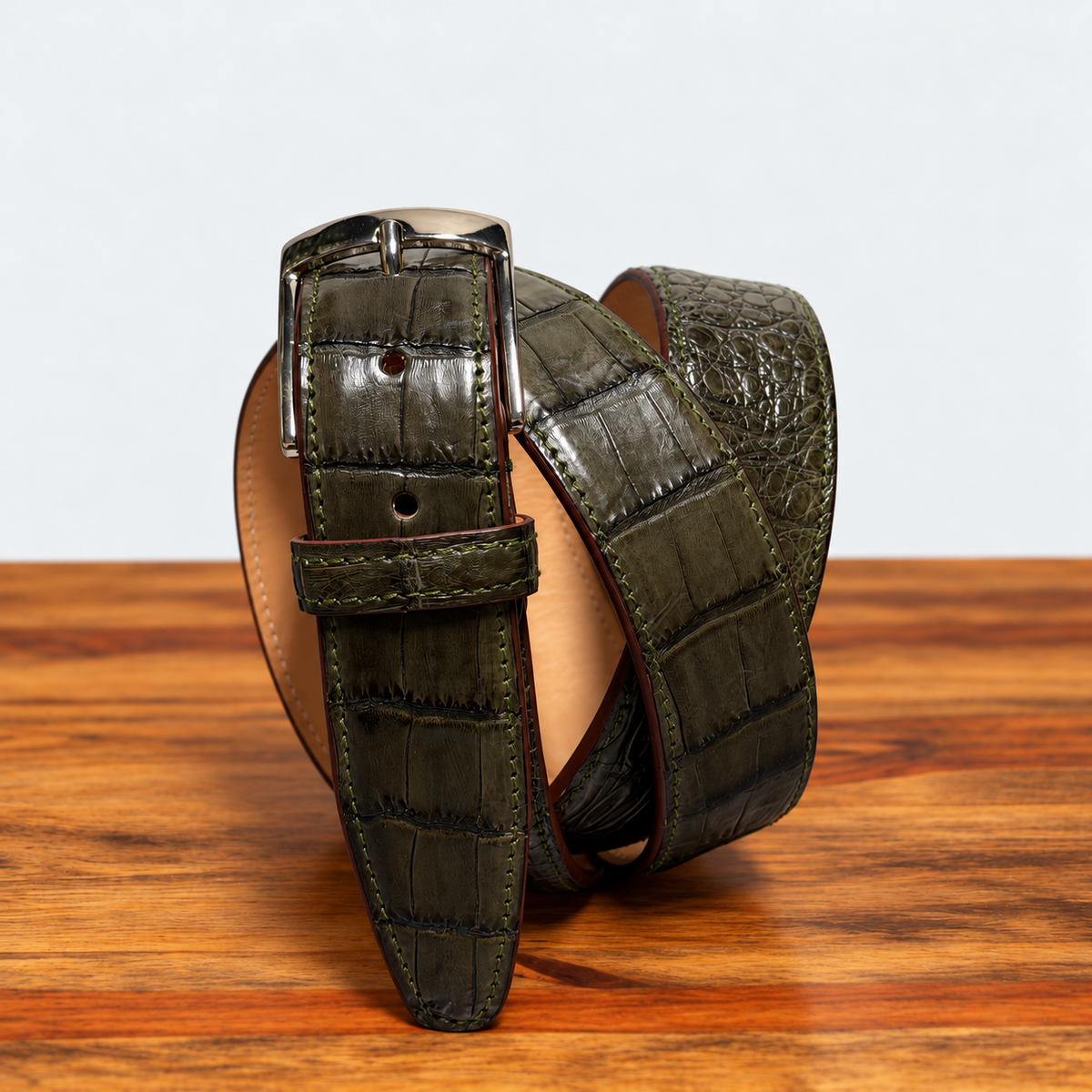 Olive Green Hornback Belt on top of a wooden table