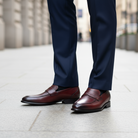 Porpora leather shoes worn with navy pants on a blurred urban background