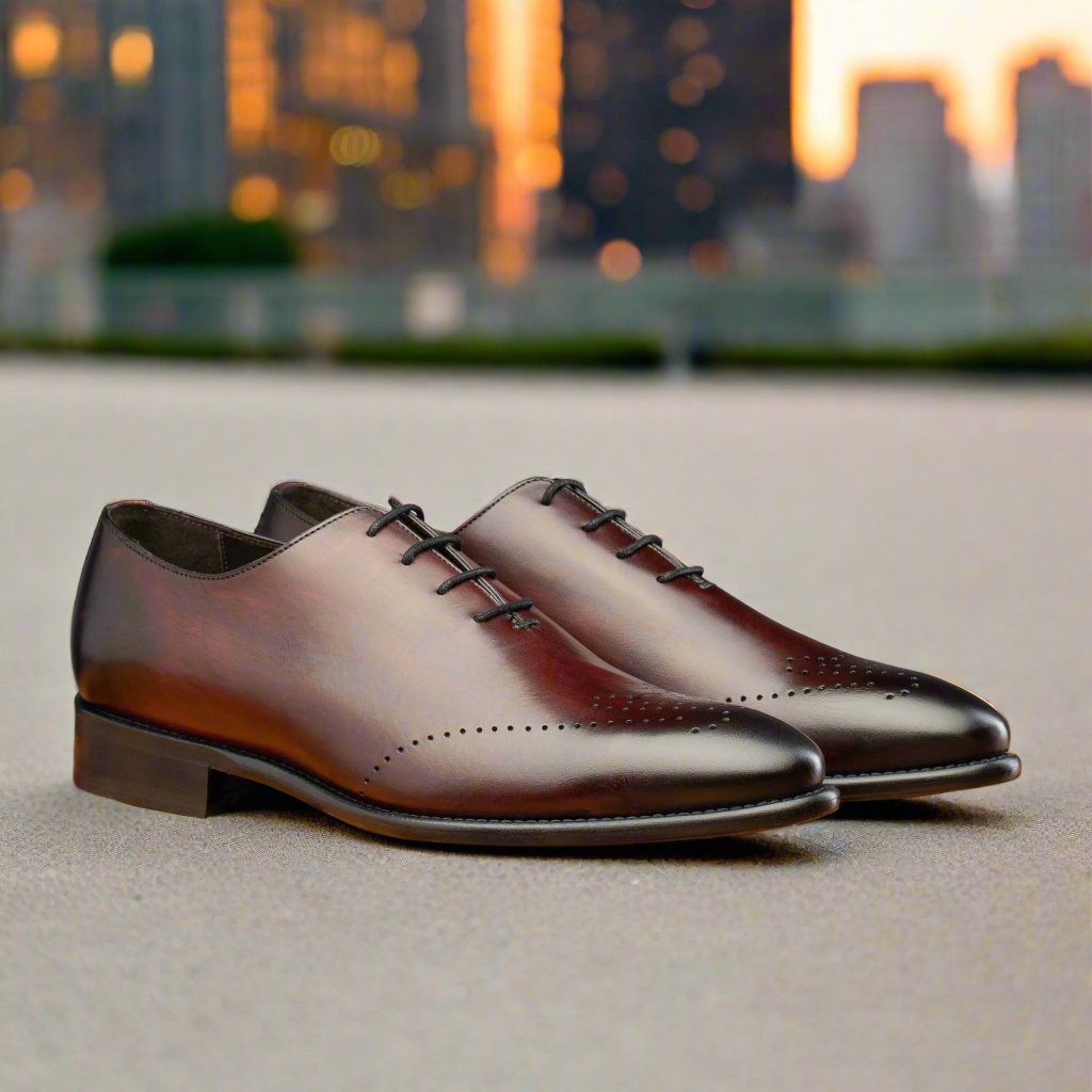 A Pair of Burgundy leather dress shoes on a blurry city background