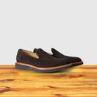A Pair of Brown Venetian loafer with a rubber sole positioned on a wooden surface.