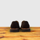A Pair of Brown Venetian loafer with a rubber sole positioned on a wooden surface.