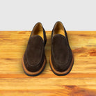 A Pair of Brown Venetian loafer with a rubber sole positioned on a wooden surface.