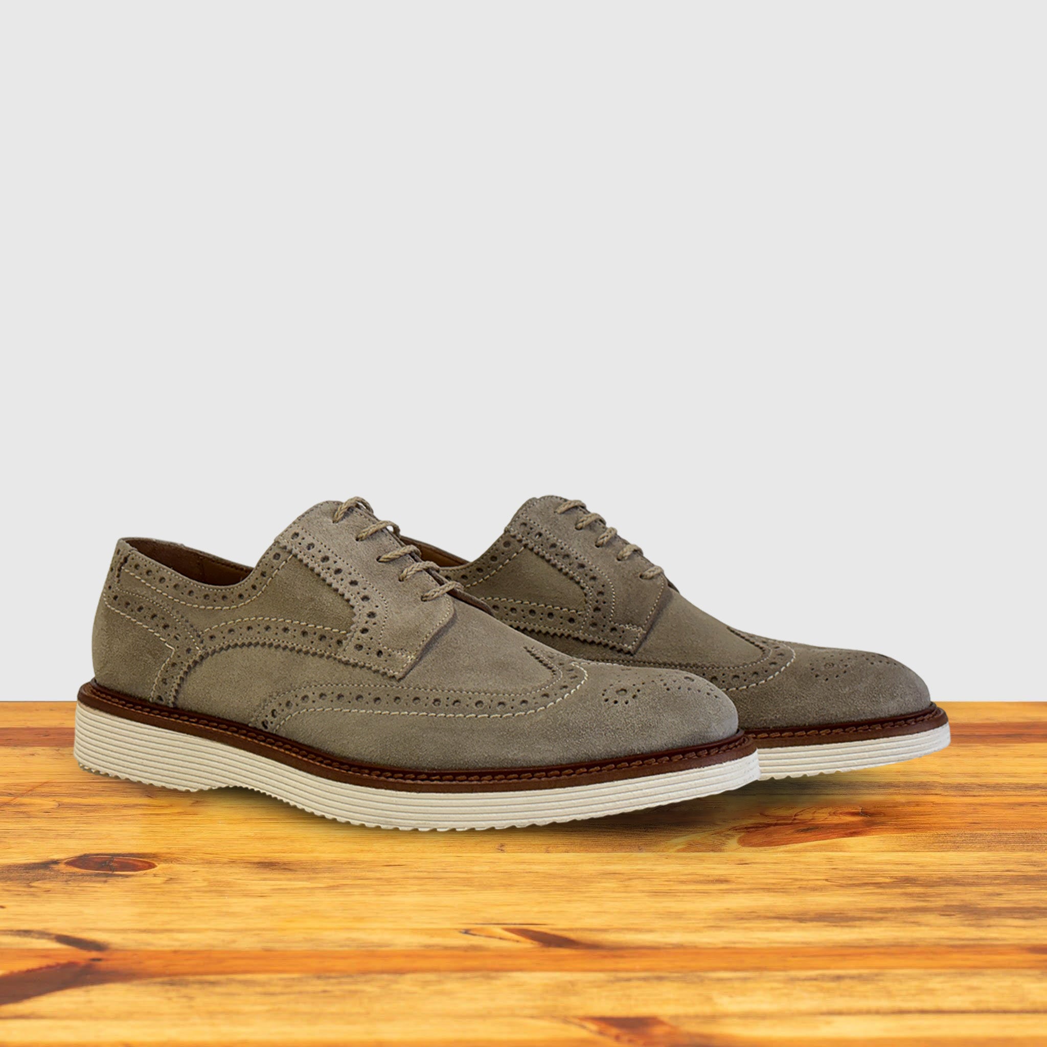 A pair of Gray suede shoe  on a wooden surface